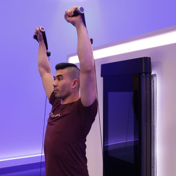 Tonal coach Tim Landicho performing an overhead press on Tonal