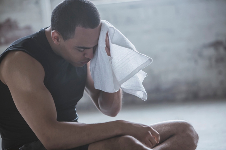 Man wiping away sweat